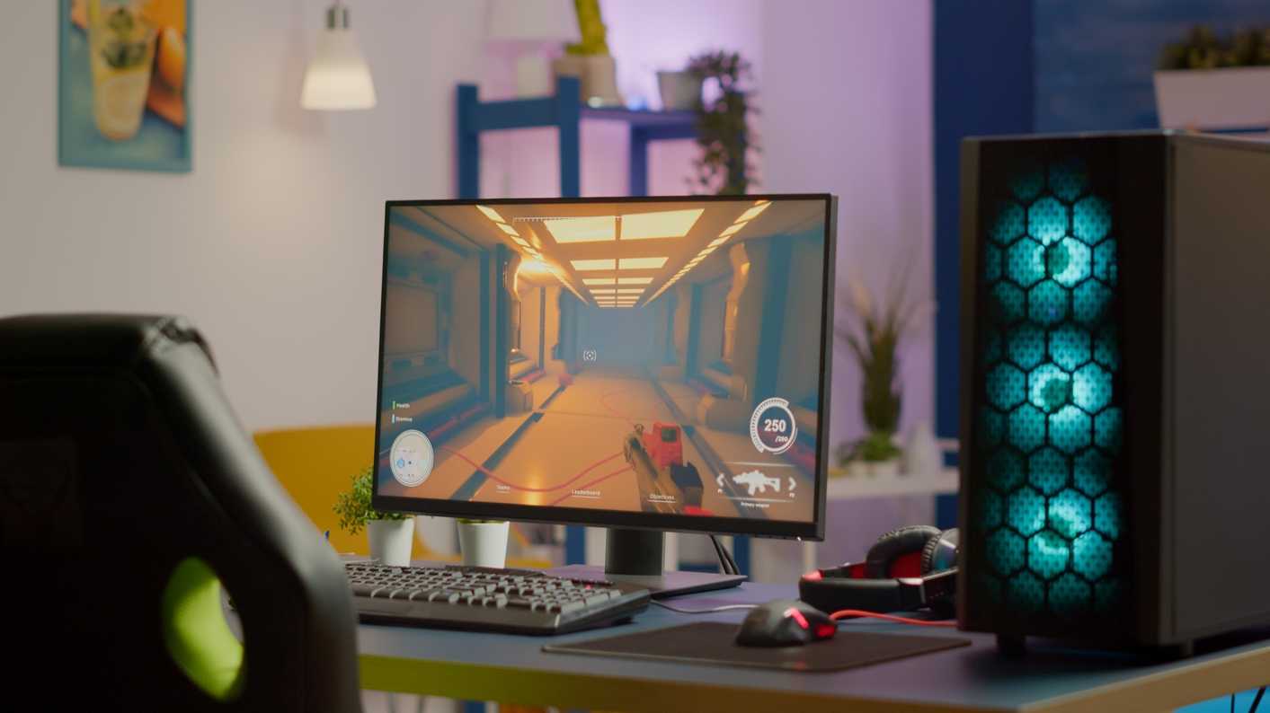 Setup de PC gamer montado em 2026 com gabinete iluminado, teclado mecânico e monitor rodando jogo em primeira pessoa