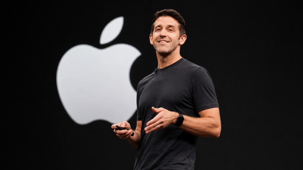 John Ternus apresentando em palco com logo da Apple ao fundo durante anúncio de nova liderança da empresa em 2026