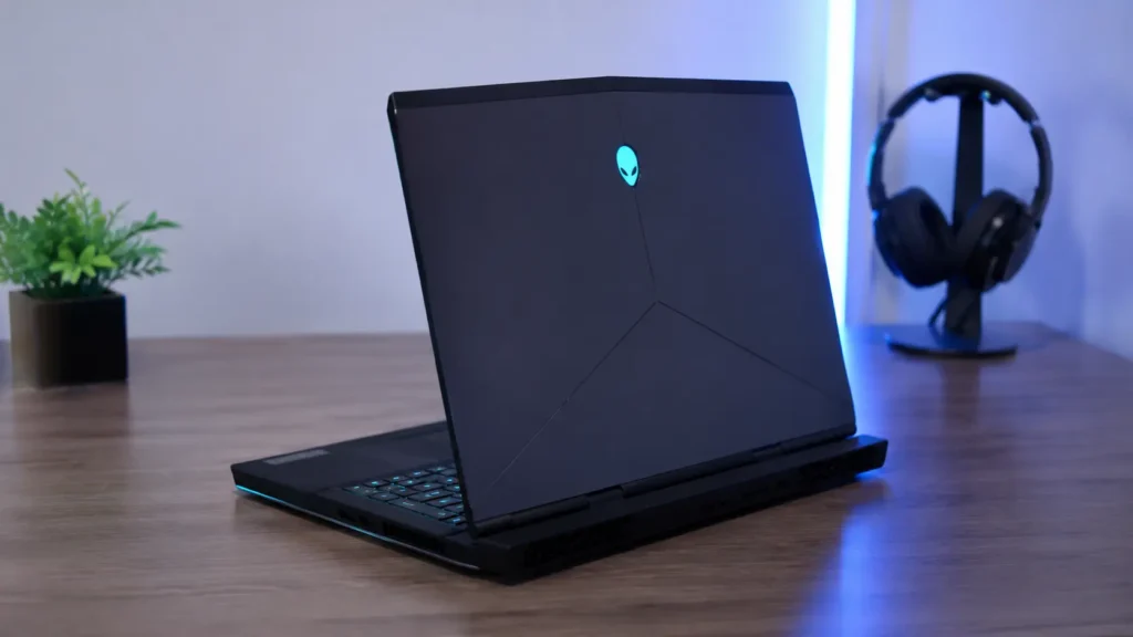 Notebook Alienware 15 em setup gamer minimalista com iluminação azul e mesa de madeira
